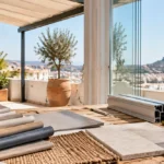 Terraza mediterránea con muestras de toldos, perfiles de vidrio y césped artificial